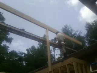 Carpenter setting a ridge beam over a new addition frame — Ice Dam Removal by Roofing Brothers in Mosby