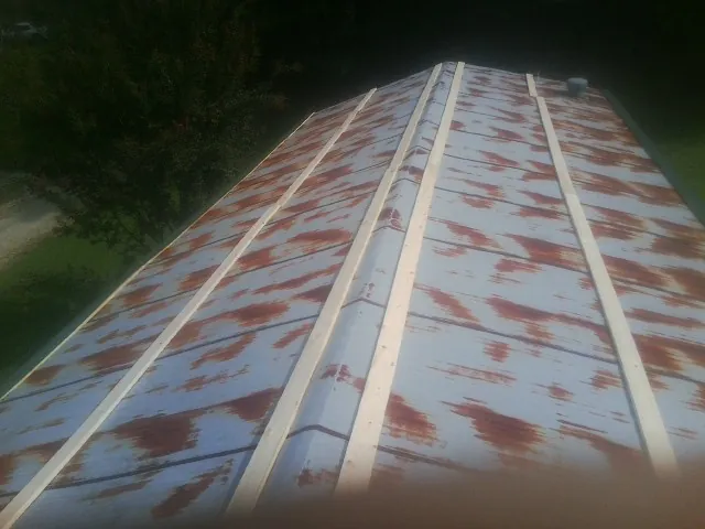 Rusted metal roof panels with new wood purlins before replacement — Storm Damage Roof Repair in Mosby by Roofing Brothers