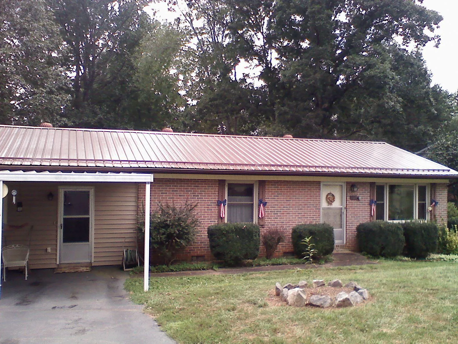 Bronze metal roof and carport on a brick ranch home — Roof Repair work by our crew in Mosby